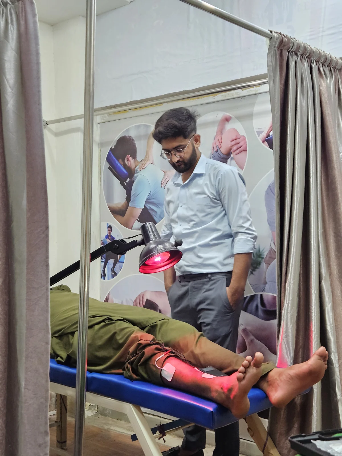 Physiotherapist treating a patient's leg with infrared heat therapy at PainFix Physiotherapy Clinic, Multan