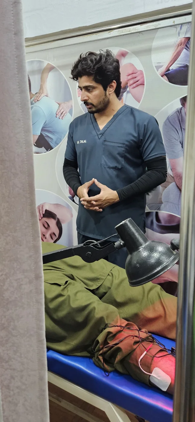 Physiotherapist using a percussion massage device for muscle recovery