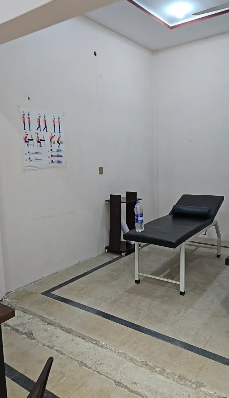 Modern, clean physiotherapy treatment room with anatomy charts at PainFix Clinic, Multan